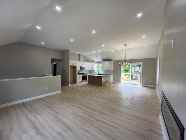 unfurnished living room featuring lofted ceiling, baseboards, light wood-type flooring, recessed lighting, and a chandelier