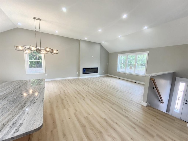 unfurnished living room featuring vaulted ceiling, light wood-type flooring, a chandelier, baseboards, and recessed lighting