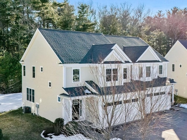 exterior space featuring central AC and roof with shingles