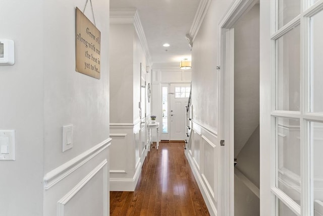 corridor with ornamental molding, recessed lighting, dark wood finished floors, and a decorative wall