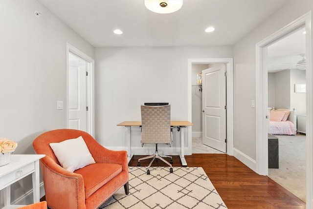 living area with baseboards, wood finished floors, and recessed lighting