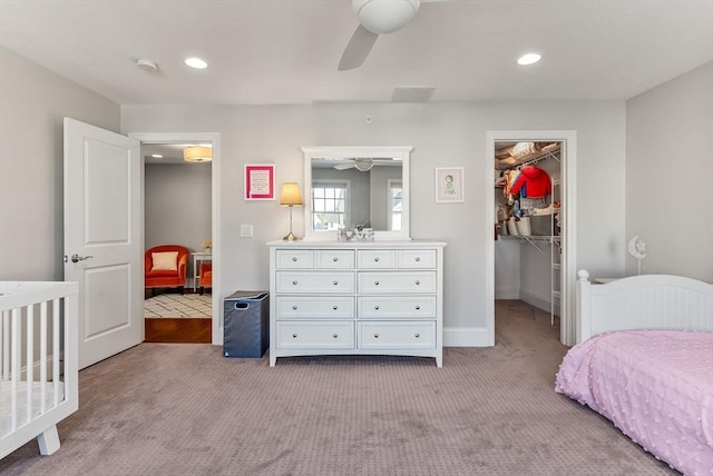 bedroom with light carpet, a spacious closet, baseboards, and recessed lighting