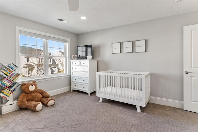 carpeted bedroom featuring recessed lighting, visible vents, ceiling fan, a nursery area, and baseboards