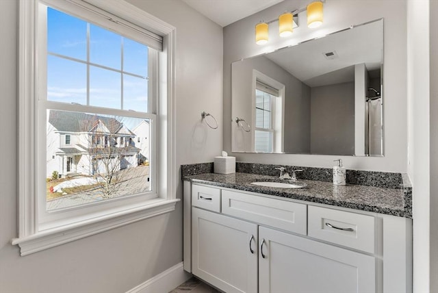 full bathroom with visible vents, vanity, and baseboards