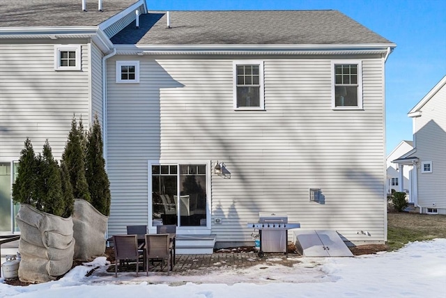 snow covered house with a shingled roof