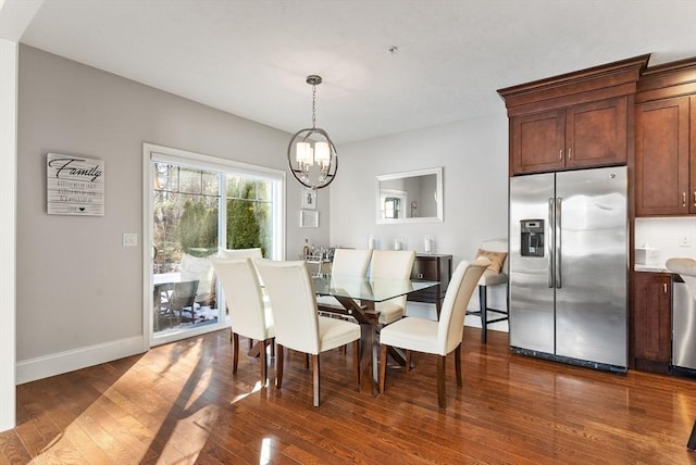 dining room with dark wood-type flooring, baseboards, and an inviting chandelier