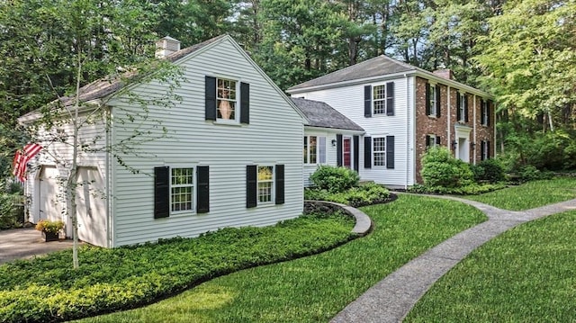 10 High Ridge Rd, Boxford, MA 01921 - view of front of house with a chimney, driveway, a front yard, view of wooded area, and roof with shingles