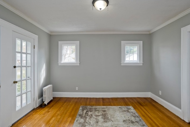 spare room featuring ornamental molding, light hardwood / wood-style floors, and radiator heating unit