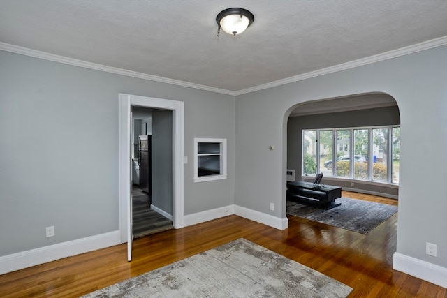 unfurnished room featuring a textured ceiling, crown molding, and dark hardwood / wood-style flooring