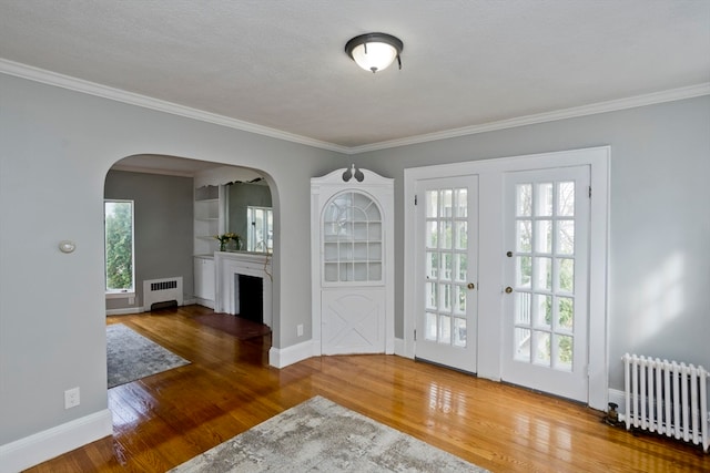 entrance foyer featuring wood-type flooring, radiator, and a wealth of natural light