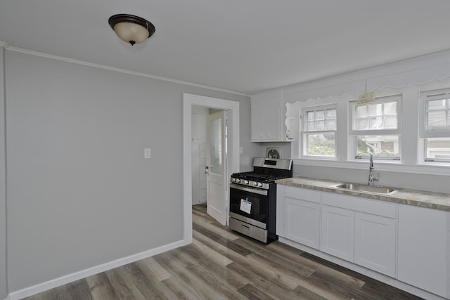 kitchen featuring sink, light hardwood / wood-style floors, stainless steel range with gas cooktop, and white cabinetry