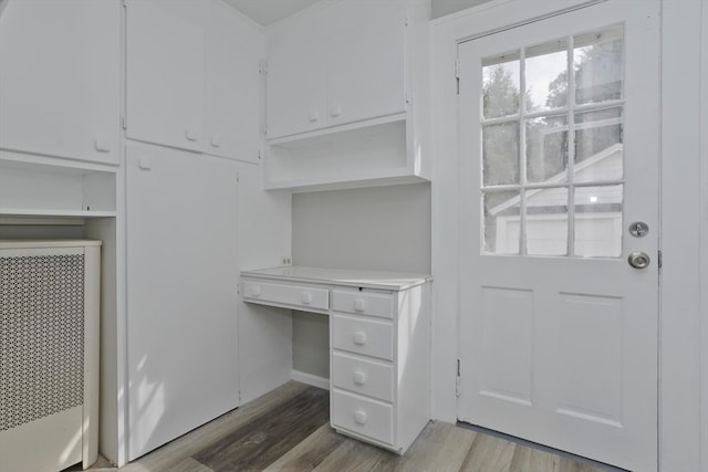 interior space featuring built in desk and hardwood / wood-style flooring