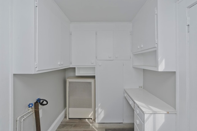 clothes washing area with dark wood-type flooring and radiator heating unit