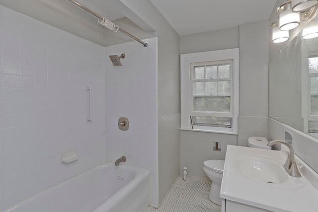 full bathroom featuring tile walls, tile patterned flooring, vanity, tiled shower / bath, and toilet