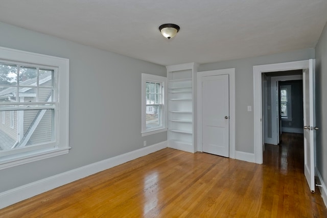 unfurnished bedroom with dark hardwood / wood-style floors and a closet