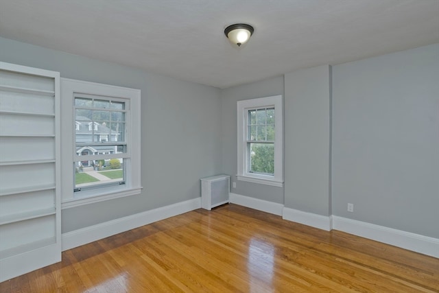 spare room featuring light wood-type flooring and built in features