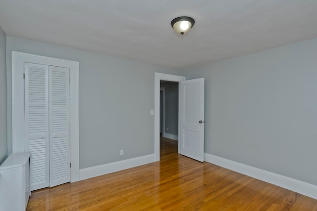 unfurnished bedroom with light hardwood / wood-style flooring and a closet