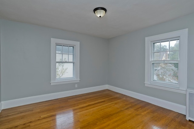 spare room featuring a healthy amount of sunlight and hardwood / wood-style floors