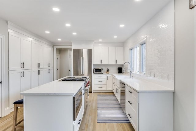 7 Colonial Dr, Chatham, MA 02633 - kitchen with a sink, a center island, light wood-style flooring, a kitchen bar, and light countertops
