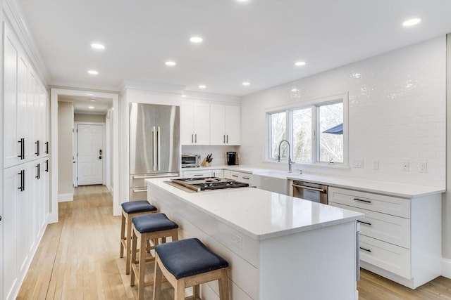 7 Colonial Dr, Chatham, MA 02633 - kitchen featuring appliances with stainless steel finishes, a sink, a breakfast bar area, a center island, and light wood-style flooring