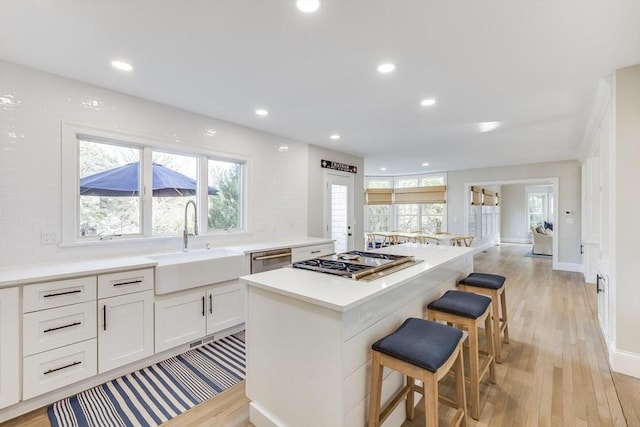 7 Colonial Dr, Chatham, MA 02633 - kitchen with a sink, stainless steel appliances, light wood-style flooring, a center island, and a breakfast bar area
