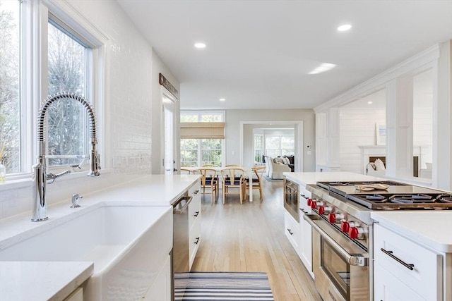 7 Colonial Dr, Chatham, MA 02633 - kitchen featuring appliances with stainless steel finishes, a sink, white cabinets, light wood-style floors, and recessed lighting