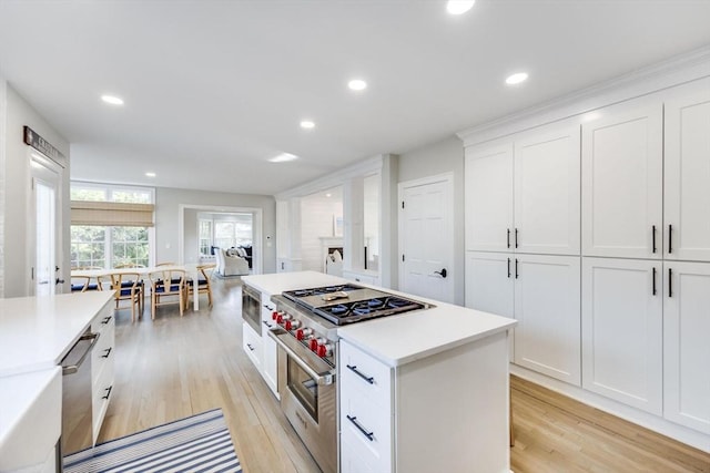 7 Colonial Dr, Chatham, MA 02633 - kitchen featuring stainless steel appliances, light wood-style flooring, white cabinetry, light countertops, and a center island