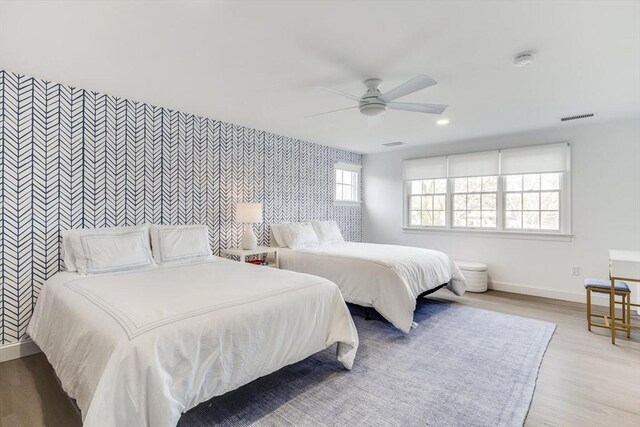 7 Colonial Dr, Chatham, MA 02633 - bedroom with an accent wall, wallpapered walls, baseboards, wood finished floors, and ceiling fan
