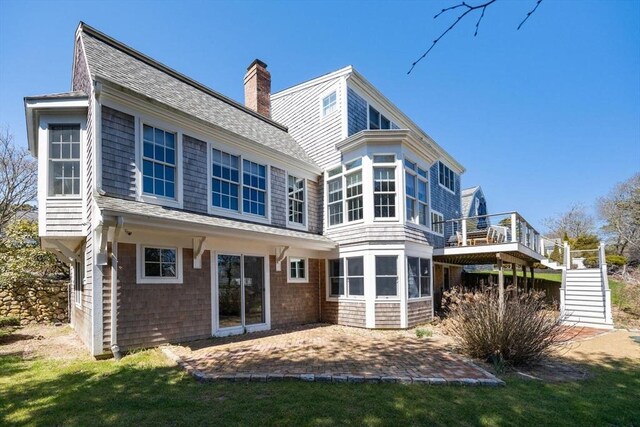 7 Colonial Dr, Chatham, MA 02633 - rear view of property featuring stairs, a shingled roof, a patio area, a chimney, and a wooden deck