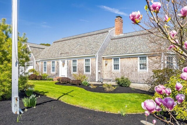 7 Colonial Dr, Chatham, MA 02633 - rear view of house featuring roof with shingles, a chimney, and a yard