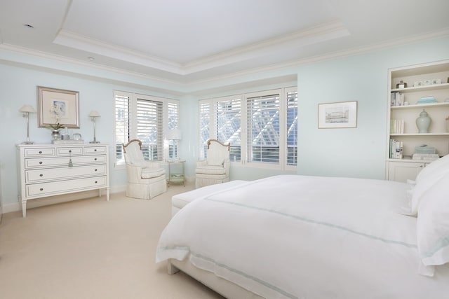 carpeted bedroom with crown molding and a tray ceiling