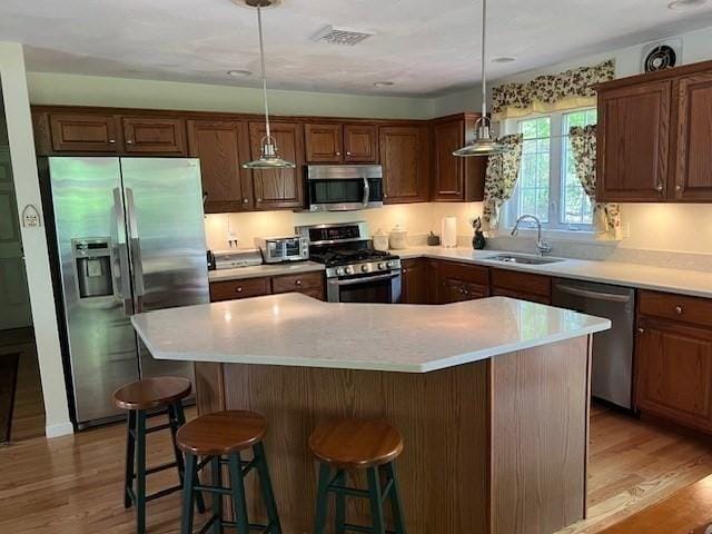 10 Atherton Rd, Hudson, MA 01749 - kitchen featuring appliances with stainless steel finishes, a sink, light wood-style flooring, a kitchen island, and light countertops