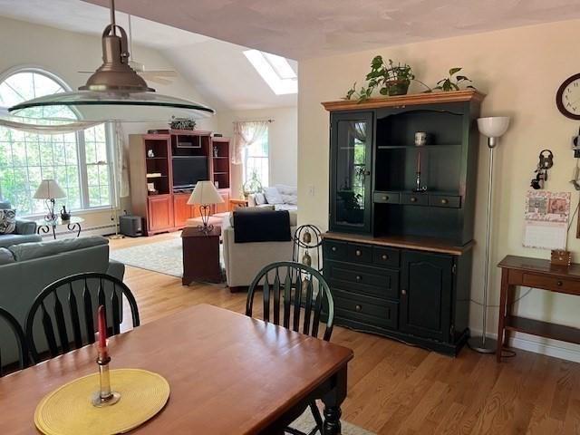 10 Atherton Rd, Hudson, MA 01749 - dining room featuring a skylight, light wood-type flooring, plenty of natural light, and lofted ceiling