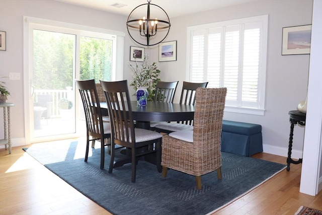 dining area with a notable chandelier, baseboards, and wood finished floors