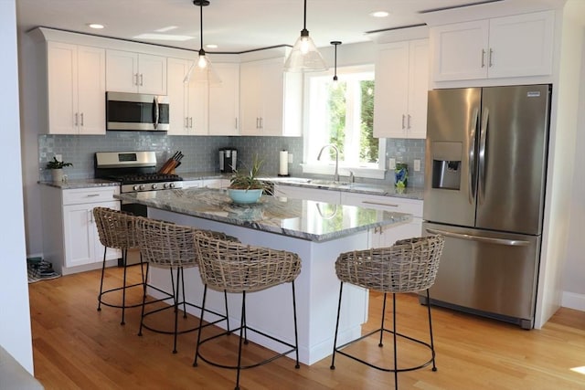 kitchen featuring appliances with stainless steel finishes, white cabinetry, and light wood-style floors