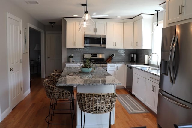 kitchen featuring a sink, appliances with stainless steel finishes, light wood-style flooring, and white cabinets