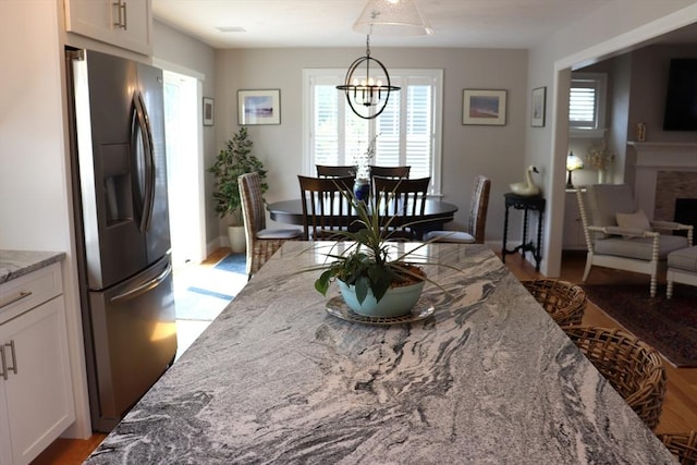 dining space featuring a fireplace and a chandelier