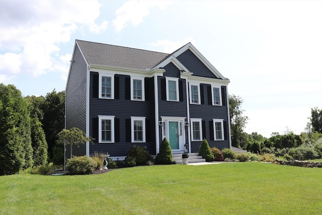 colonial-style house featuring a front yard