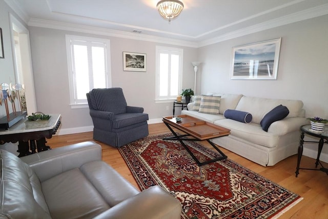 living area featuring a healthy amount of sunlight, crown molding, baseboards, and wood finished floors