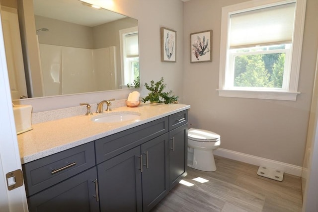 full bath with walk in shower, baseboards, toilet, wood finished floors, and vanity