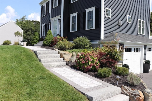 view of side of property featuring a lawn and a garage