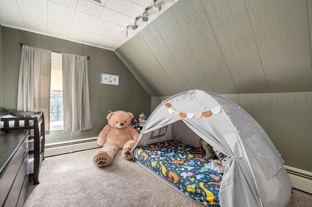 bedroom with carpet floors, vaulted ceiling, wooden walls, and baseboard heating