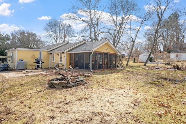 back of property with a sunroom and an outbuilding