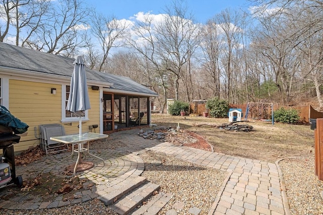 view of patio with fence and a sunroom