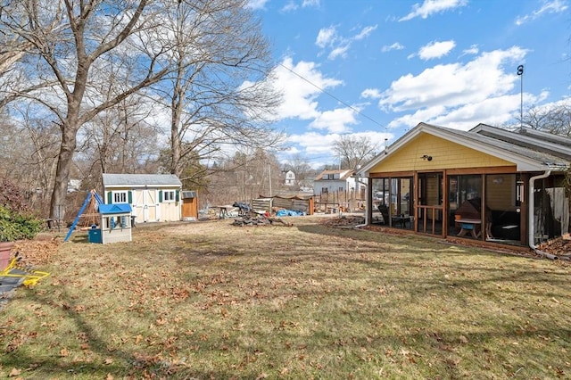 view of yard with a shed, an outdoor structure, and a sunroom