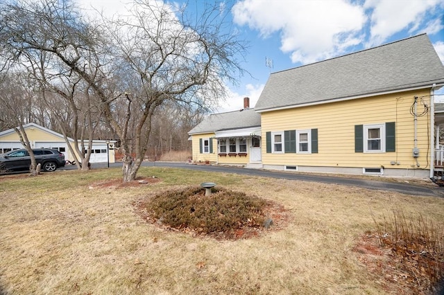 exterior space with a yard and a shingled roof