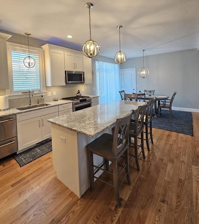 38 John Perkins Way, Middleboro, MA 02346 - kitchen with stainless steel appliances, a sink, wood finished floors, white cabinets, and recessed lighting