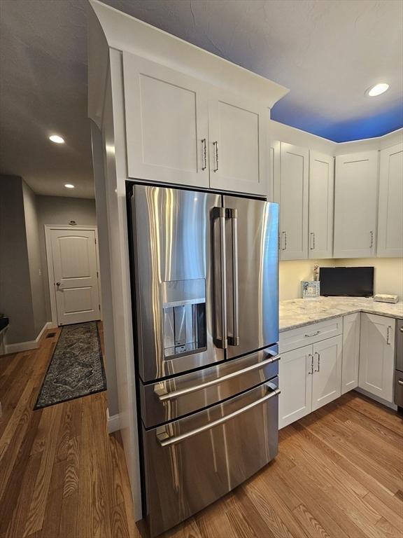 38 John Perkins Way, Middleboro, MA 02346 - kitchen with stainless steel refrigerator with ice dispenser, wood finished floors, white cabinets, light stone counters, and recessed lighting