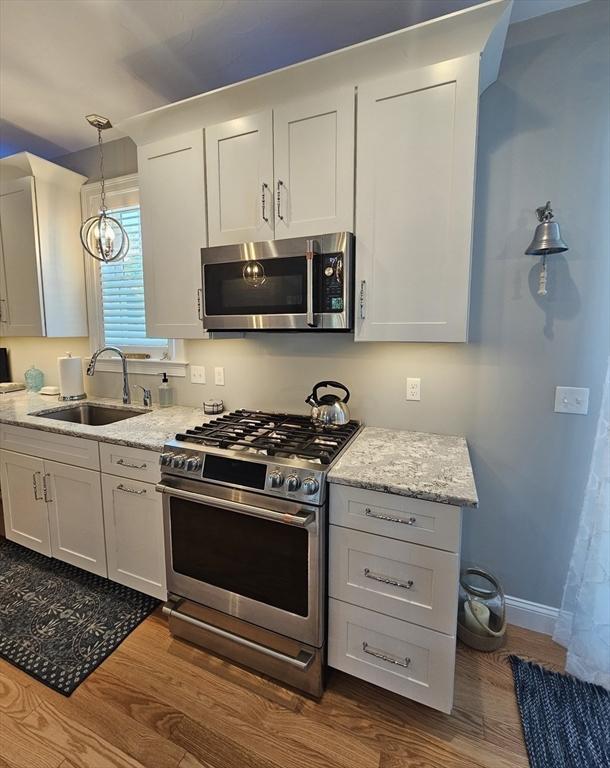 38 John Perkins Way, Middleboro, MA 02346 - kitchen with stainless steel appliances, a sink, dark wood finished floors, and decorative light fixtures