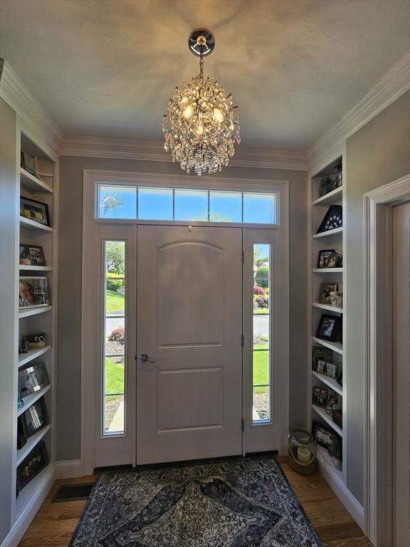38 John Perkins Way, Middleboro, MA 02346 - foyer with healthy amount of natural light, a chandelier, wood finished floors, and crown molding